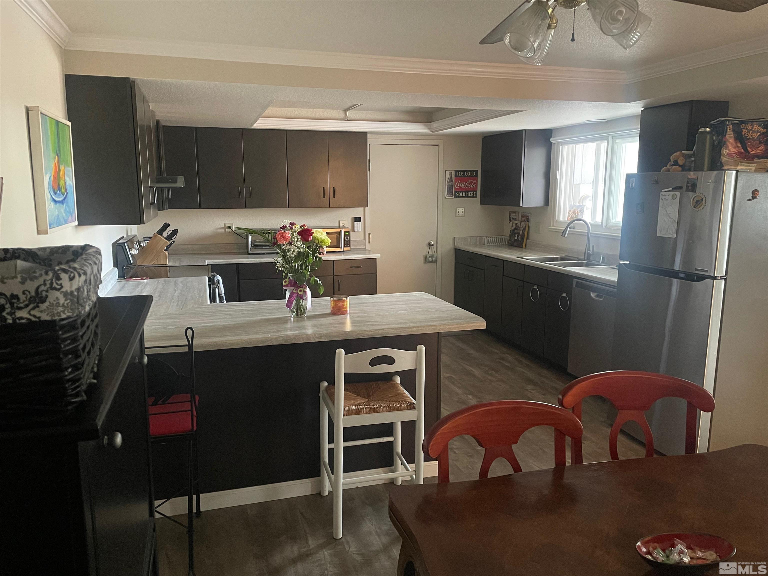7550 Bluestone Drive Reno, NV 89511 - Photo 6 of 15 a kitchen with stainless steel appliances granite countertop a sink a stove a refrigerator and chairs