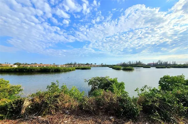 a view of a lake with green landscape and trees