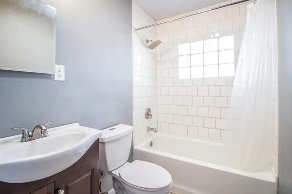 a white bath tub sitting next to a white sink and a toilet