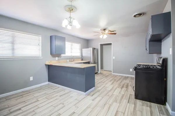 a kitchen with a refrigerator and a stove top oven