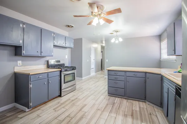 a kitchen with kitchen island granite countertop a sink cabinets and stainless steel appliances