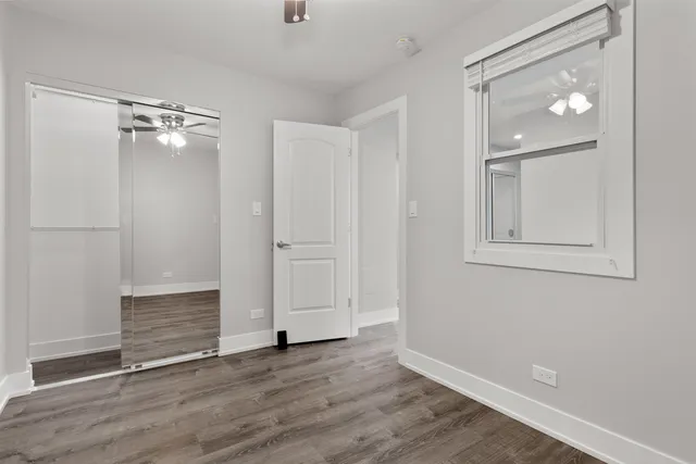 an empty room with wooden floor and closet