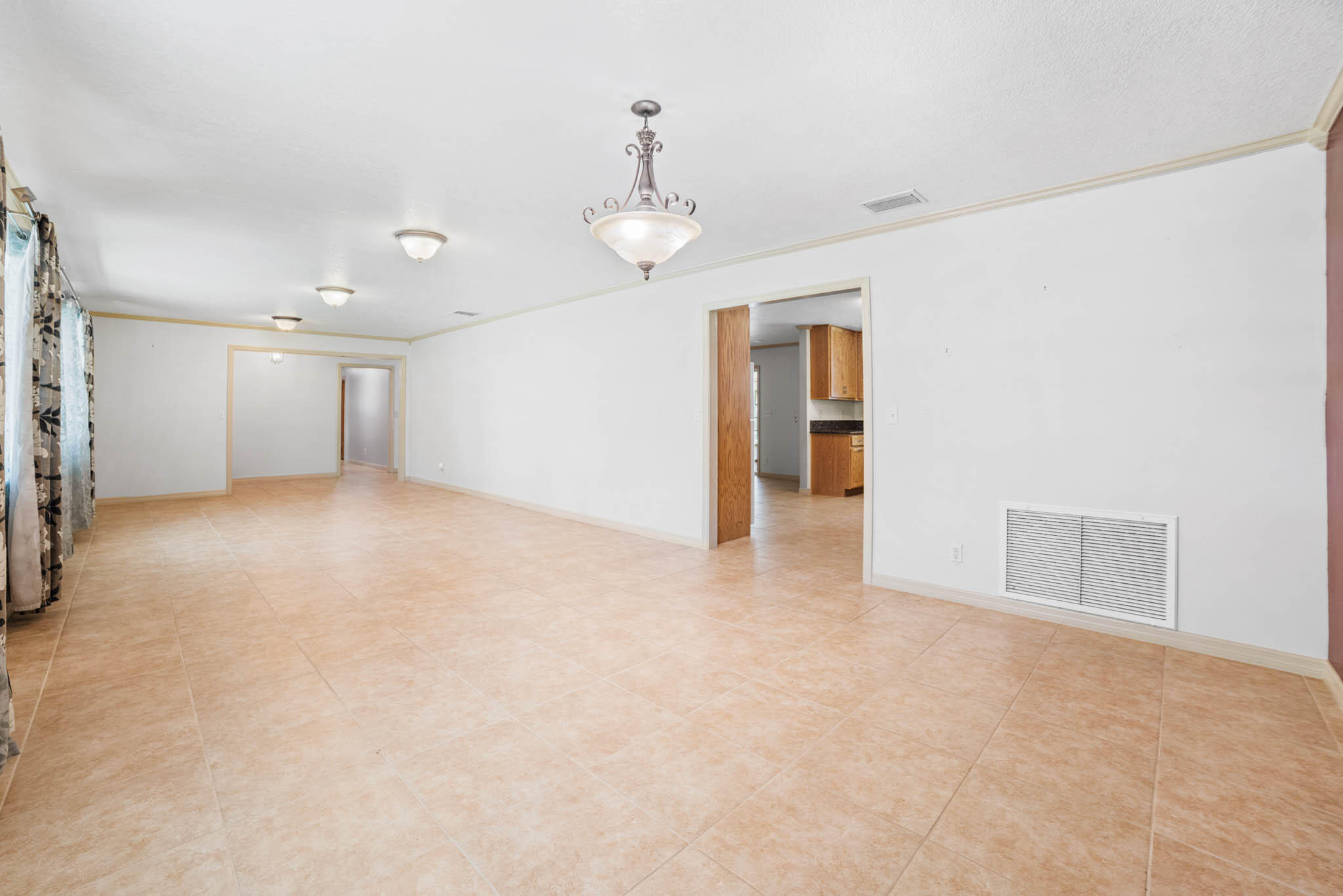 409 Southwest 15th Street Okeechobee, FL 34974 - Photo 5 of 14 an empty room with chandelier fan and windows