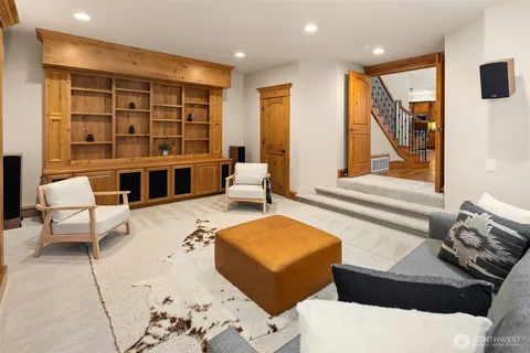 a living room with furniture a large window and wooden floor