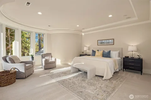 a spacious bedroom with a bed a couch and a large window