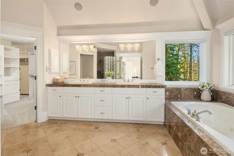 a spacious bathroom with a granite countertop tub sink and mirror