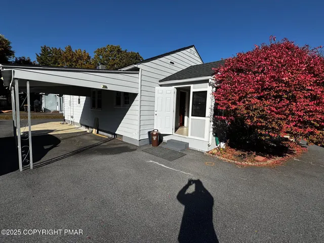 a view of a chair and table in the back yard of the house