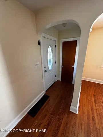 a view of a hallway with wooden floor