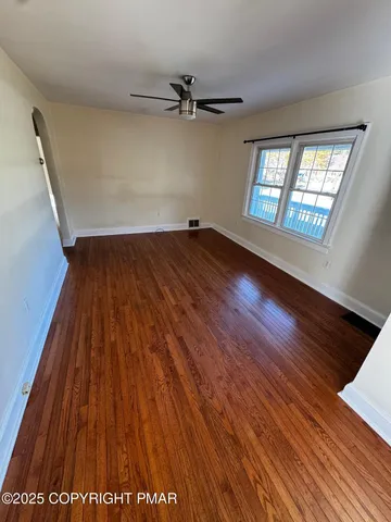 wooden floor in an empty room with a window