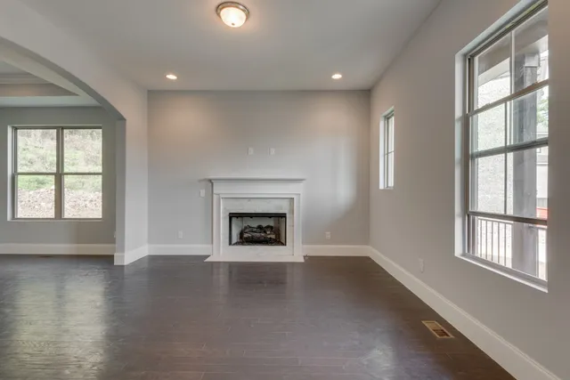 a view of a livingroom with wooden floor and a fireplace