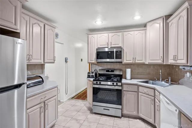 a kitchen with white cabinets and appliances