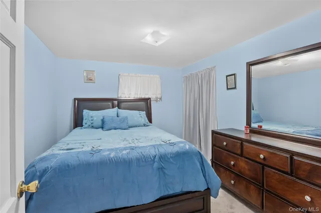 a bedroom with a bed and a mirror on dresser