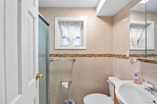 a bathroom with a sink a toilet and mirror