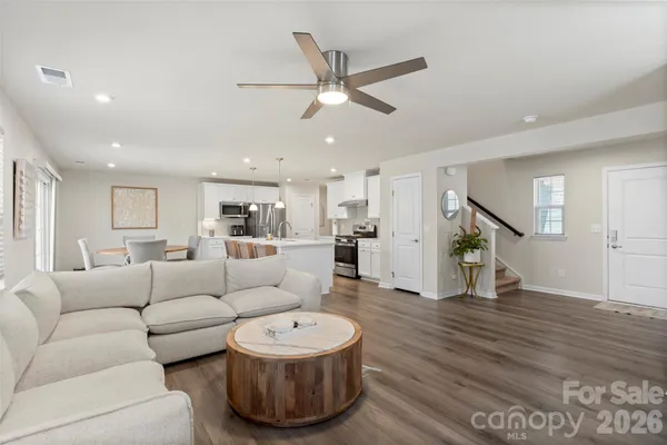 a living room with furniture and a wooden floor