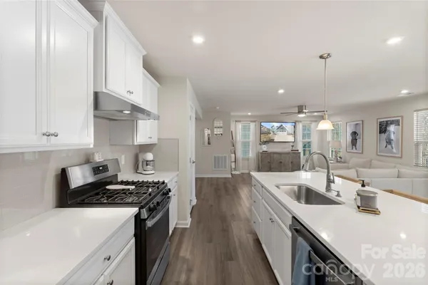 a kitchen with granite countertop a sink stove and cabinets