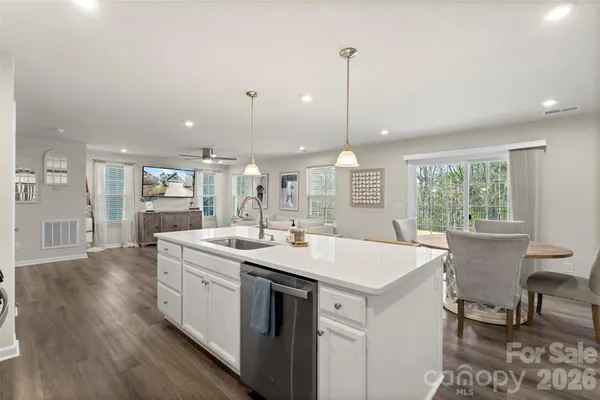 a open kitchen with a sink a stove a dining table and chairs