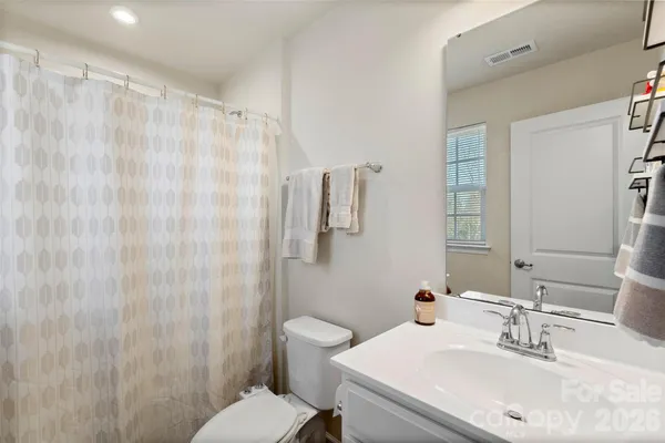 a bathroom with a sink a toilet and shower curtain