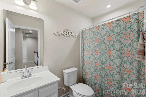 a bathroom with a sink a toilet and shower curtain