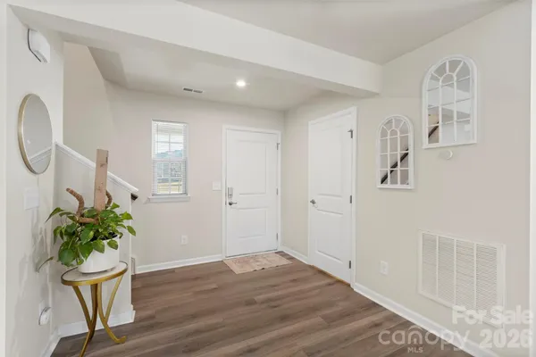 a view of a room with wooden floor potted plant and windows