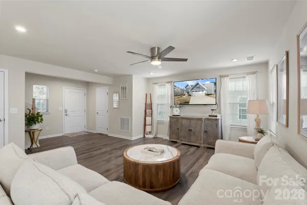 a living room with furniture and a wooden floor