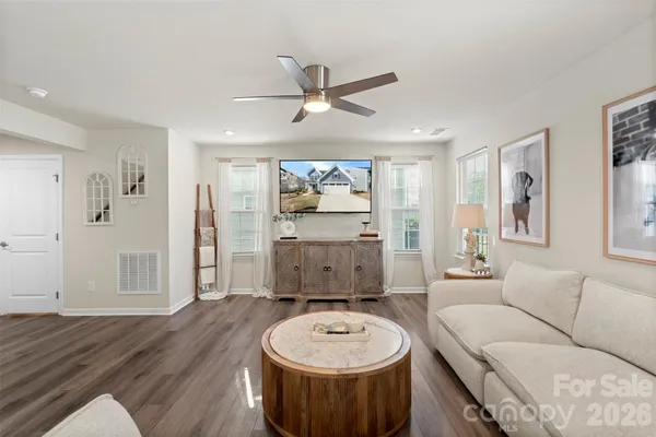 a living room with furniture and a wooden floor