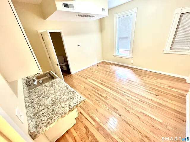 a view of a bedroom with wooden floor and entrance