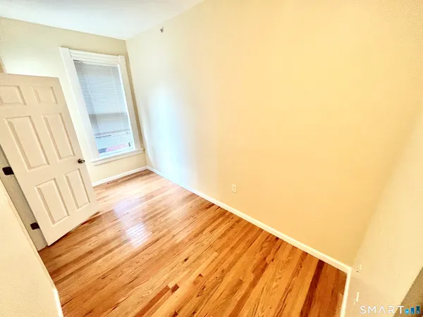 a view of a room with wooden floor and a hallway