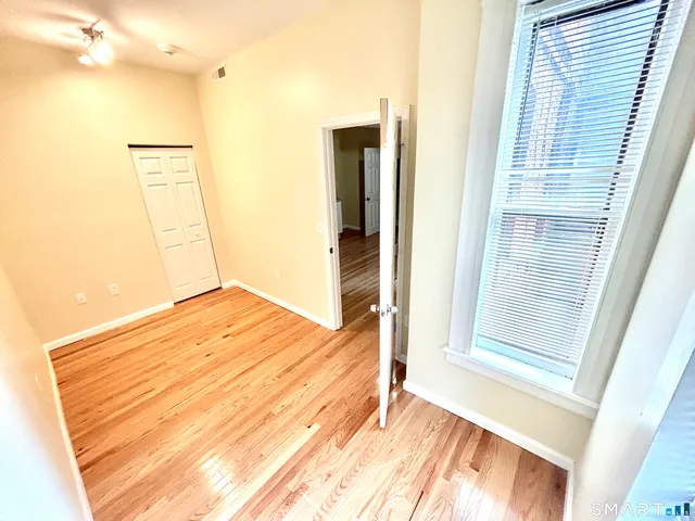 a view of a room with wooden floor and a bathroom