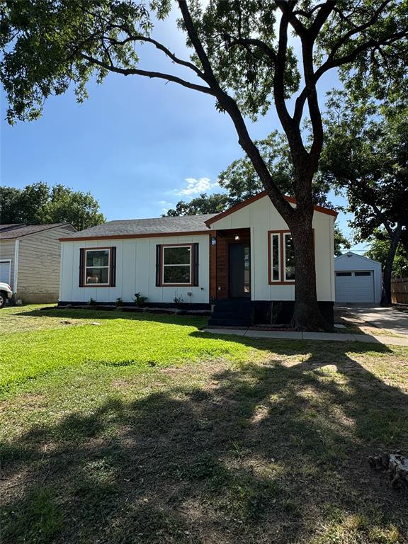 901 Rindie Street Irving, TX 75060 - Photo 1 of 1 View of front facade featuring an outdoor structure, a front yard, board and batten siding, and a detached garage