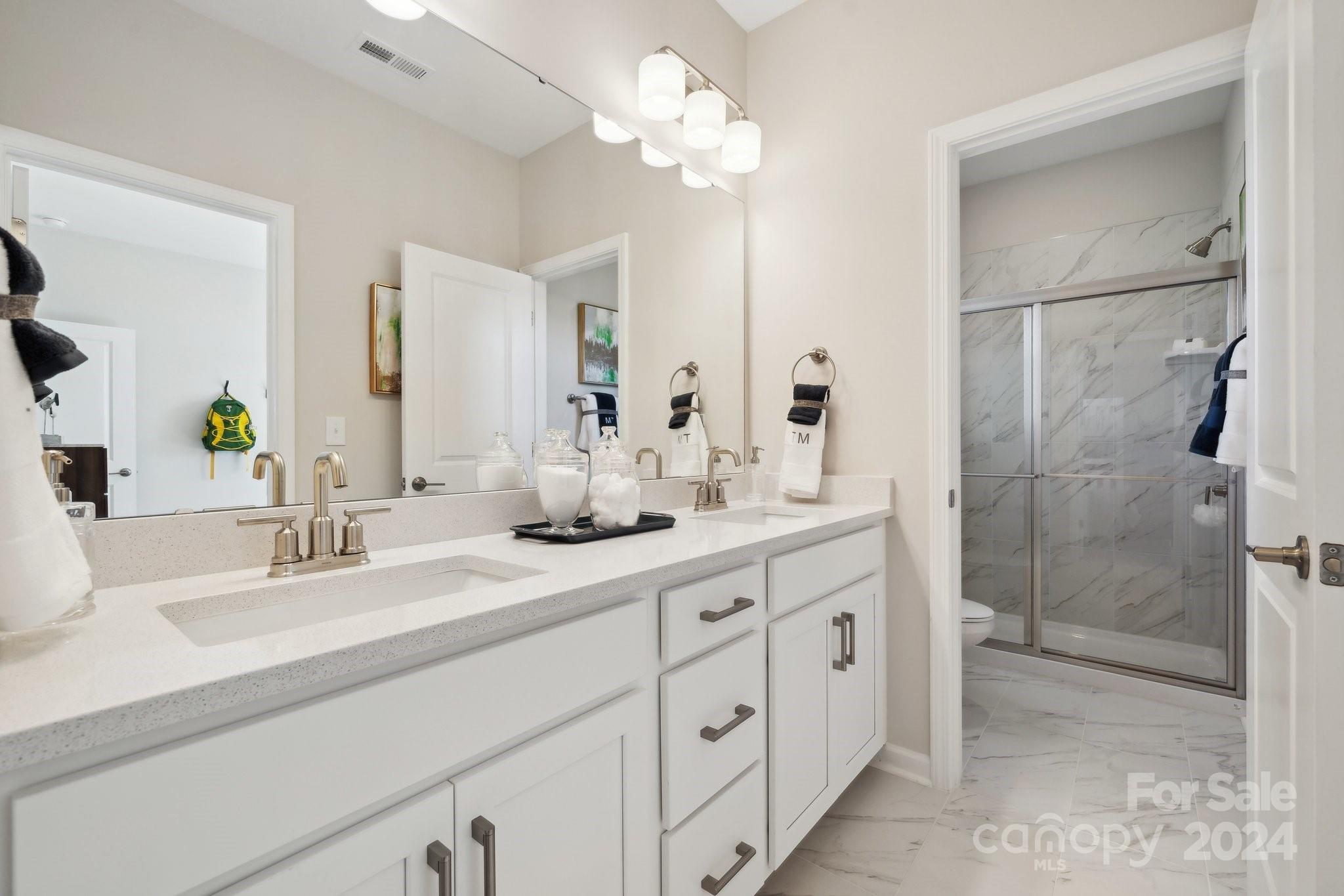 1414 Hubert Graham Way Tega Cay, SC 29708 - Photo 25 of 28 a bathroom with a double vanity sink mirror and shower