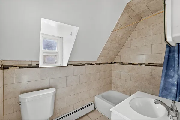 a bathroom with a toilet a sink and mirror