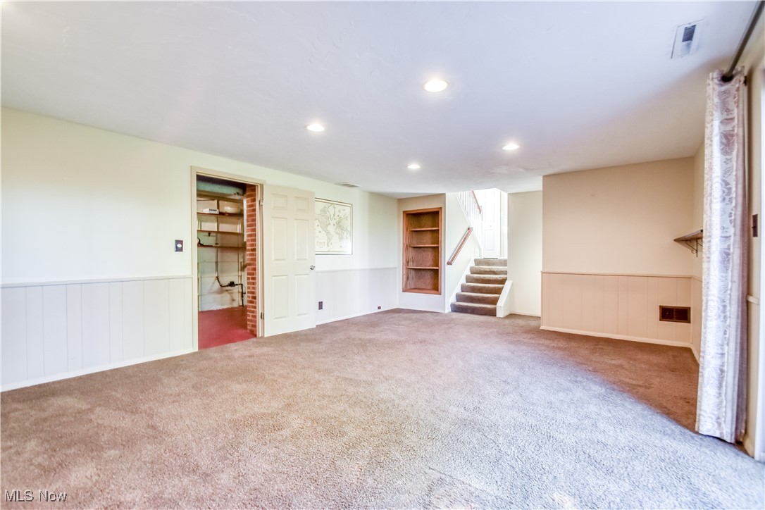 6145 Hemingway Road Cleveland, OH 44143 - Photo 40 of 50 Spare room with wainscoting, recessed lighting, built in shelves, stairs, and carpet floors