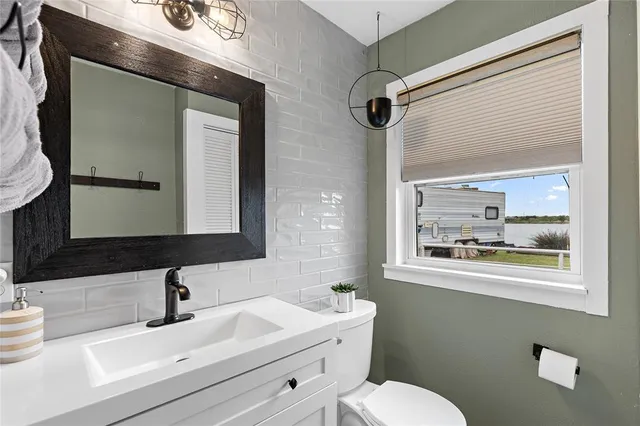 a bathroom with a sink mirror and toilet