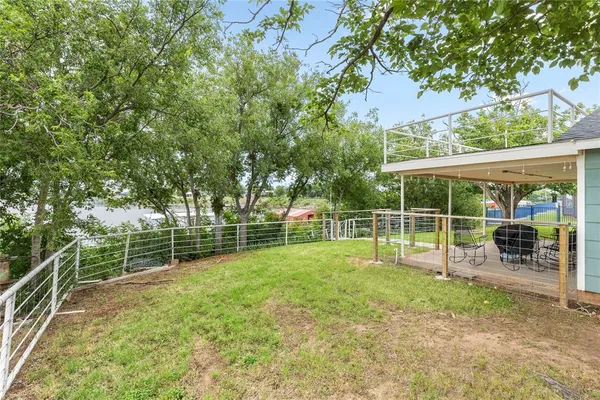 a view of a yard with a house and a large tree
