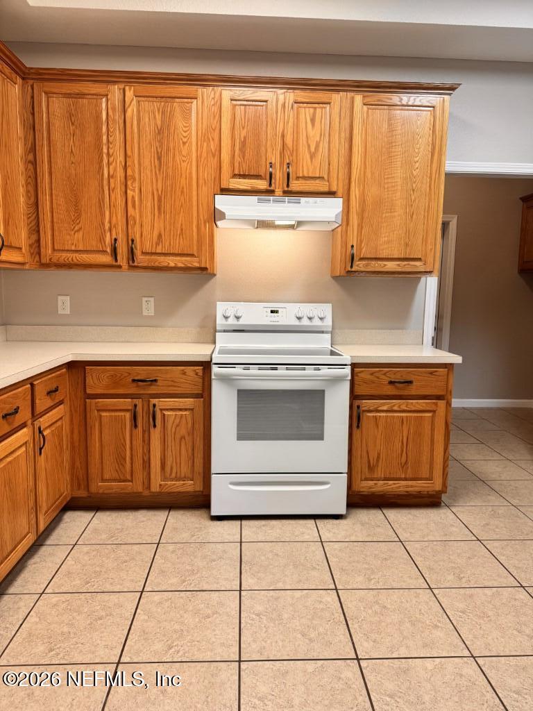 1467 Rivers Road Green Cove Springs, FL 32043 - Photo 10 of 22 a kitchen with a stove top oven cabinets and a refrigerator