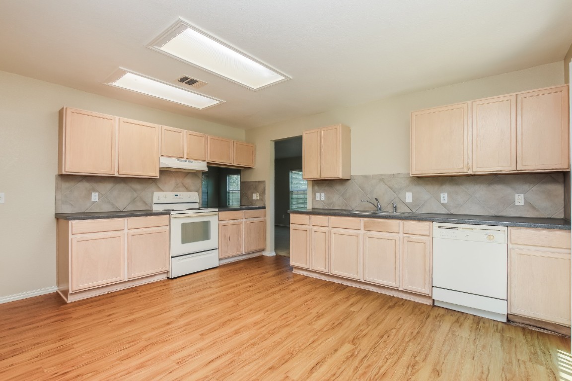 4311 Cisco Valley Drive Round Rock, TX 78664 - Photo 7 of 18 a kitchen with granite countertop white cabinets and white appliances