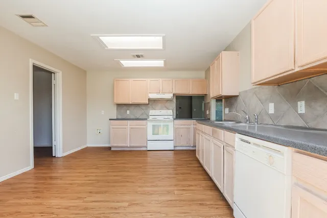 a kitchen with granite countertop white cabinets and white appliances