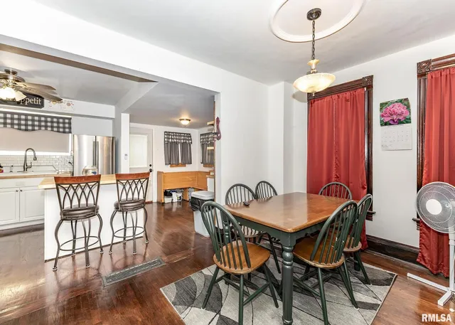 a dining room with furniture a chandelier and wooden floor