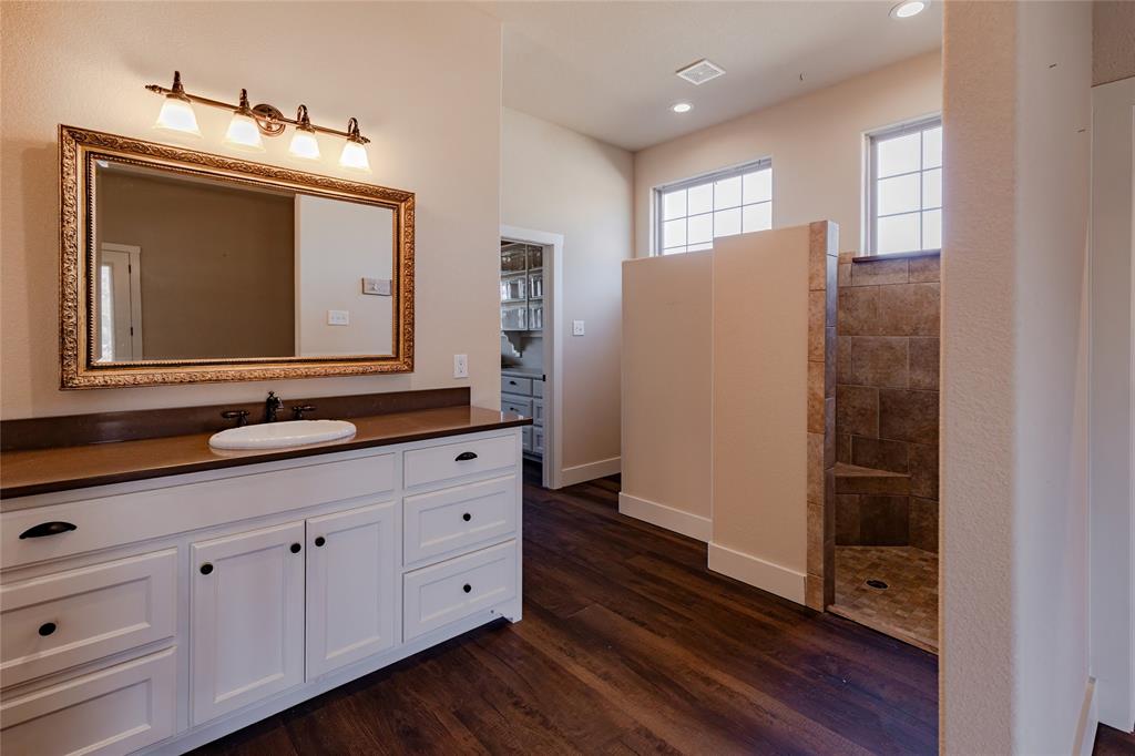 1433 County Road 1180 Decatur, TX 76234 - Photo 16 of 36 a bathroom with a double vanity sink and mirror
