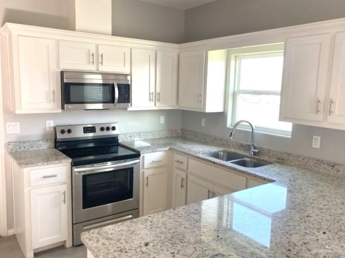 1904 Davenport Street, Unit 4 Weslaco, TX 78596 - Photo 5 of 11 a kitchen with stainless steel appliances granite countertop a sink a stove and microwave