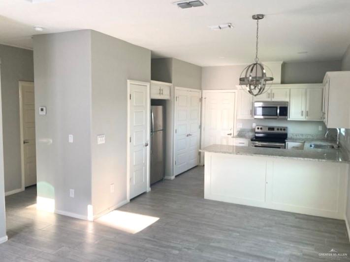 1904 Davenport Street, Unit 4 Weslaco, TX 78596 - Photo 8 of 11 a view of a kitchen with granite countertop stainless steel appliances and a chandelier