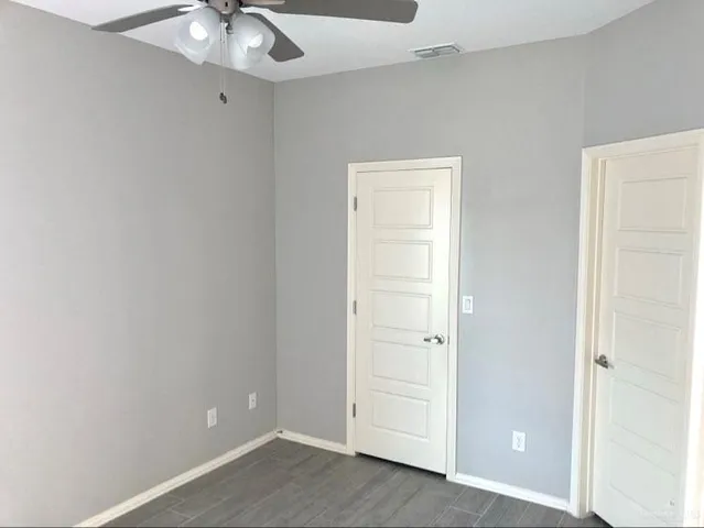an empty room with chandelier fan