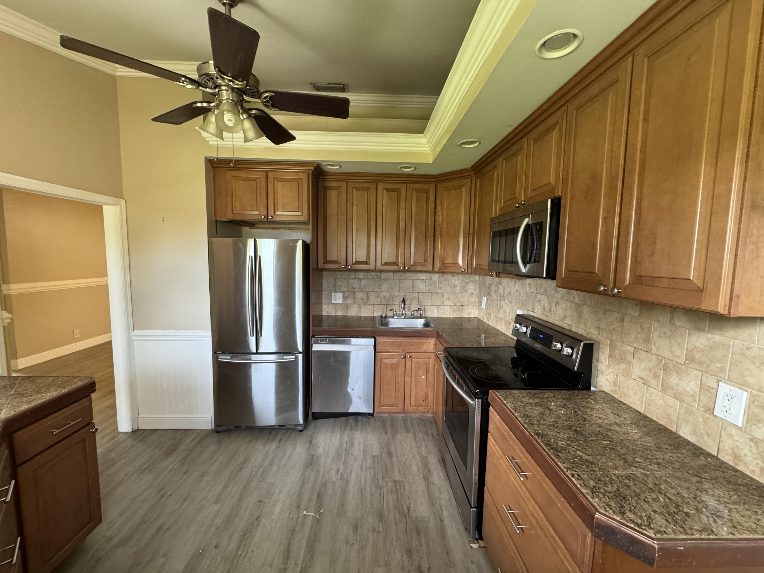 10115 Patience Lane Royal Palm Beach, FL 33411 - Photo 5 of 8 a kitchen with a refrigerator a microwave and sink