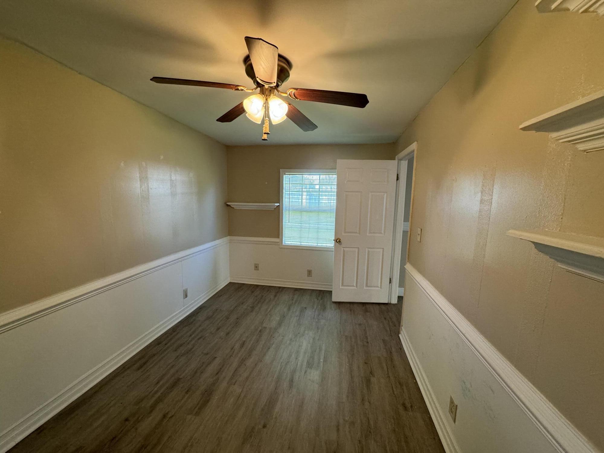 10115 Patience Lane Royal Palm Beach, FL 33411 - Photo 7 of 8 a view of an empty room with a window and wooden floor