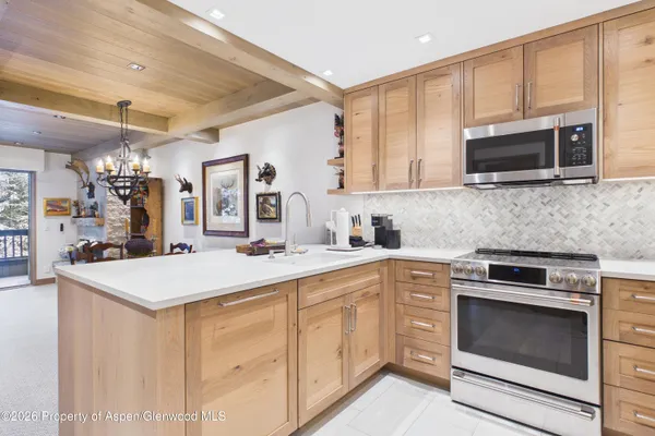 a kitchen with stainless steel appliances granite countertop a stove microwave and cabinets