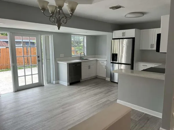 a kitchen with stainless steel appliances granite countertop a refrigerator and a stove top oven