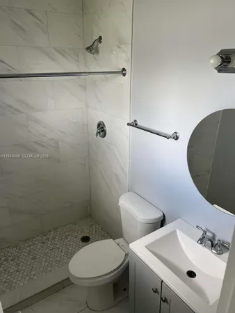 a white toilet sitting next to a bathroom sink