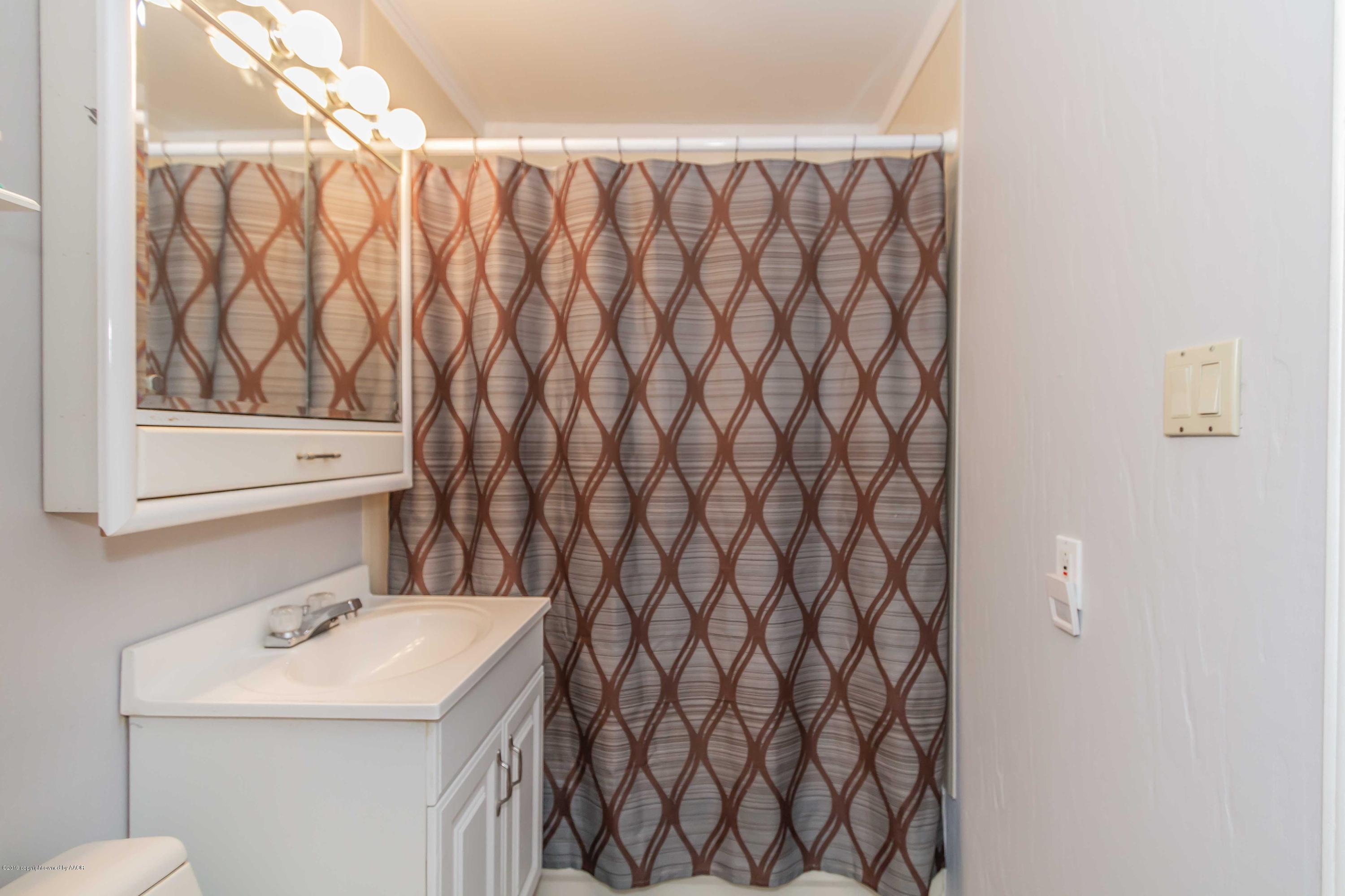 4417 South Hayden Street Amarillo, TX 79110 - Photo 22 of 36 a bathroom with a sink and a mirror