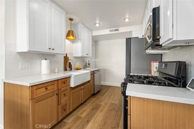 a kitchen with stainless steel appliances granite countertop a stove a sink and a refrigerator
