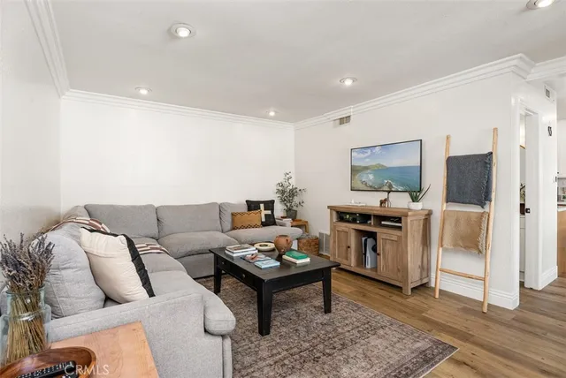 a living room with furniture a kitchen view and a refrigerator